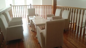 A spacious room with a wooden floor, white furniture, and a balcony with a wooden railing. - Solar food&drink campsite (Dezhou)