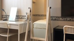 A hotel room with a desk, two chairs, a bed, and a mirror. - BUSINESS HOTEL La Firenze (Tokyo)