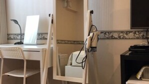 A room with a desk, chair, and a white standing lamp. - BUSINESS HOTEL La Firenze (Tokyo)