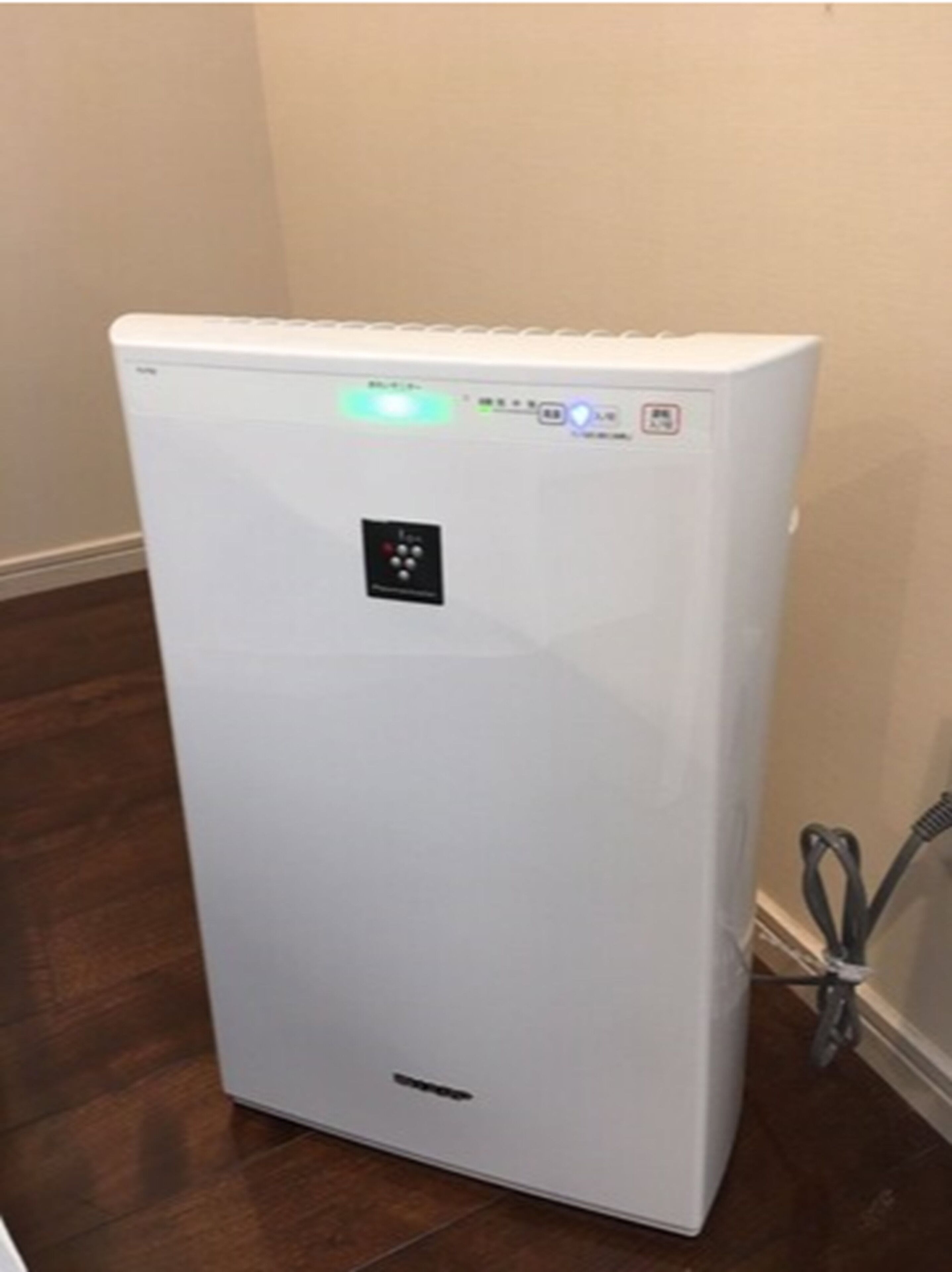 A white portable air conditioner with a control panel and a power cord.