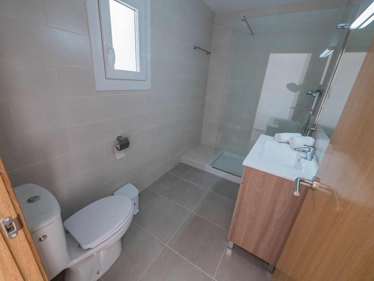 Une salle de bain comprenant des toilettes, un espace douche et un lavabo avec un miroir.