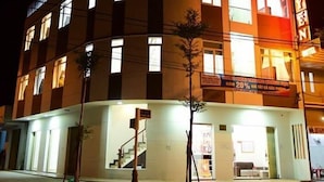 Um hotel com fachada curva, várias janelas e uma placa de destaque.