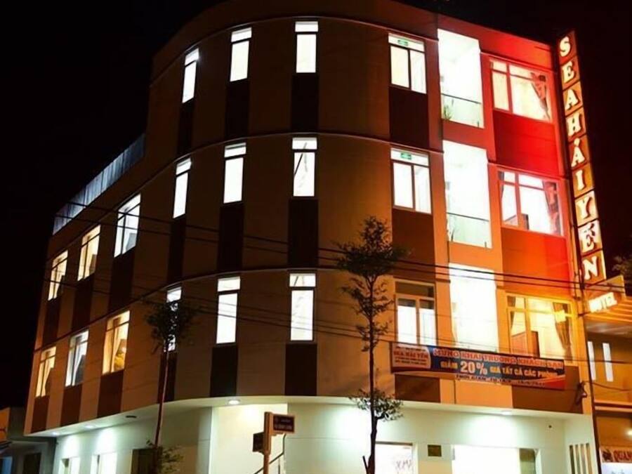 Un hotel con fachada curva, numerosas ventanas y un cartel llamativo.