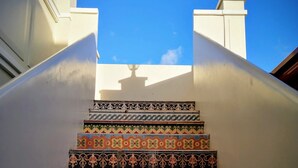 Una escala amb rajoles ornamentals i de colors que condueix a un balcó.