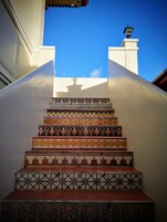 A staircase with ornate, colorful tiles leading to a balcony.