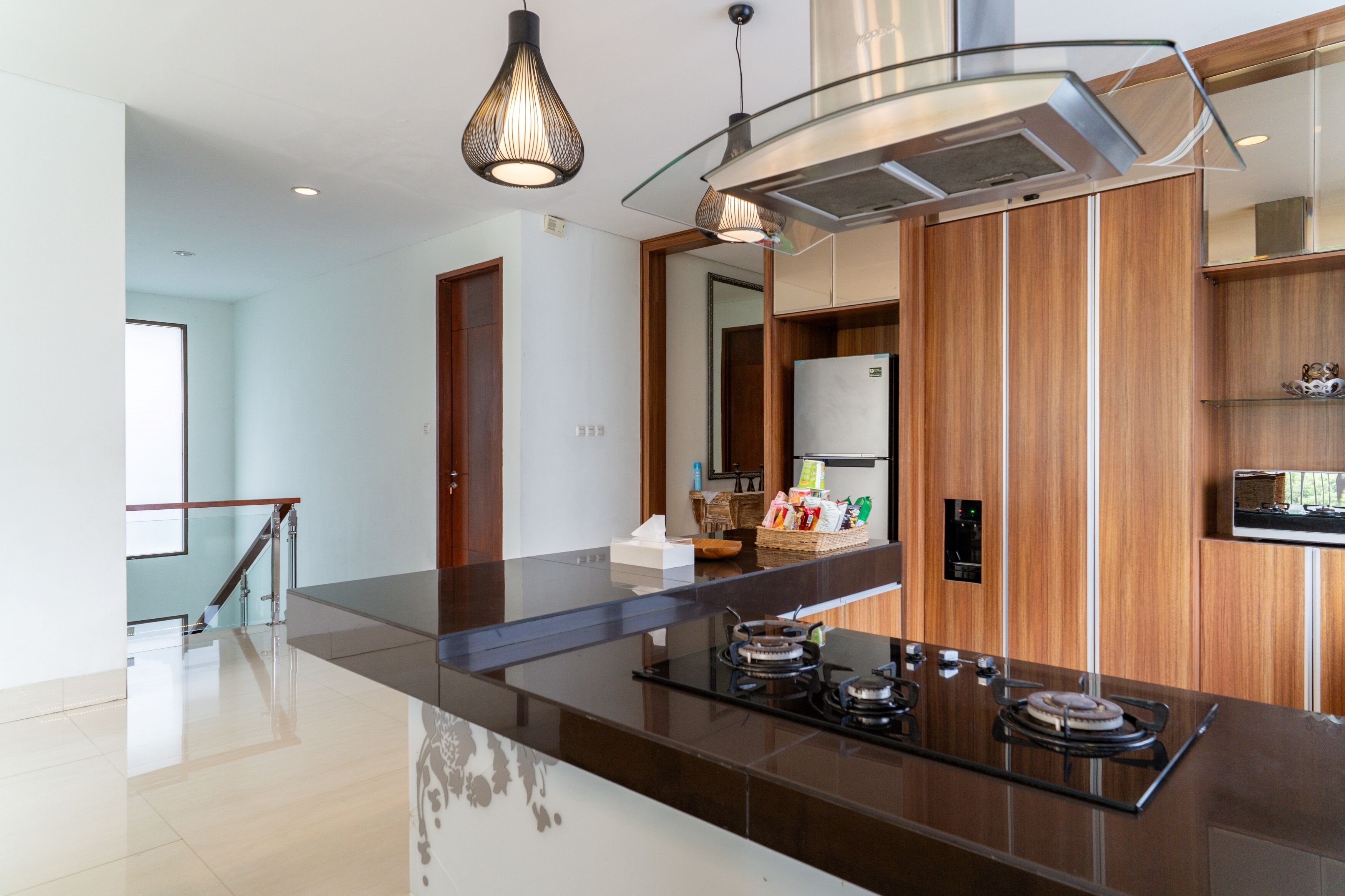 Una cocina moderna con una isla central, electrodomésticos de acero inoxidable y muebles de madera.