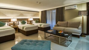 A hotel room with two beds, a sofa, a coffee table, and a lamp. - J7 Hotel Iloilo (Iloilo)