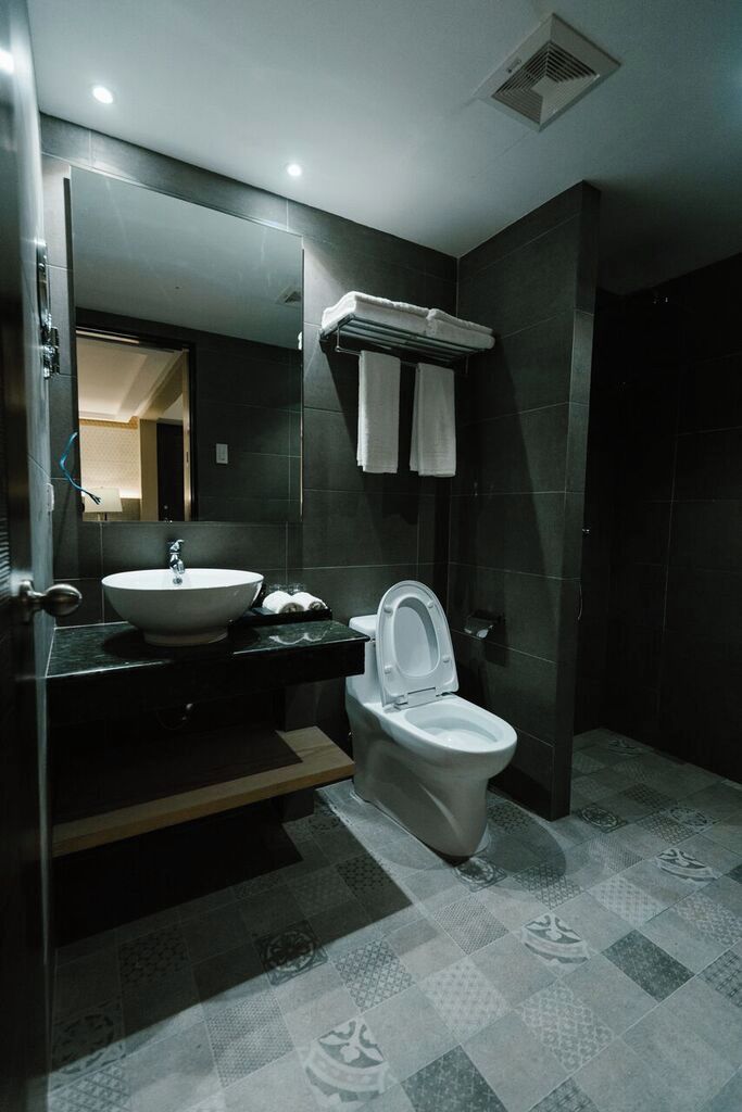 Un baño moderno con lavamanos, inodoro y espejo.