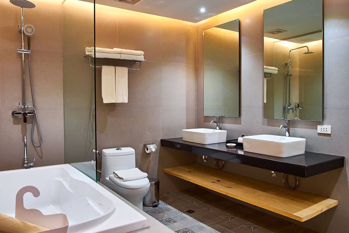 A modern bathroom with a freestanding bathtub, a double sink vanity, and a large mirror above the vanity.