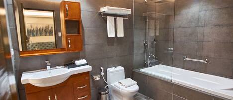 A modern bathroom with a vanity, toilet, and bathtub.