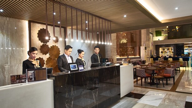 A hotel reception area with a modern design, featuring a reception desk, seating area, and a bar. - J7 Hotel Iloilo (Iloilo)