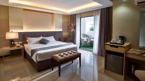 A hotel room with a bed, bedside table, lamp, and a small desk with a coffee maker. - J7 Hotel Iloilo (Iloilo)