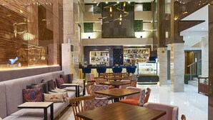 A spacious lobby with a modern design, featuring a seating area with sofas and tables, a bar, and a high ceiling with unique lighting fixtures. - J7 Hotel Iloilo (Iloilo)