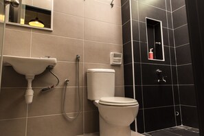 A bathroom with a toilet, sink, and shower.