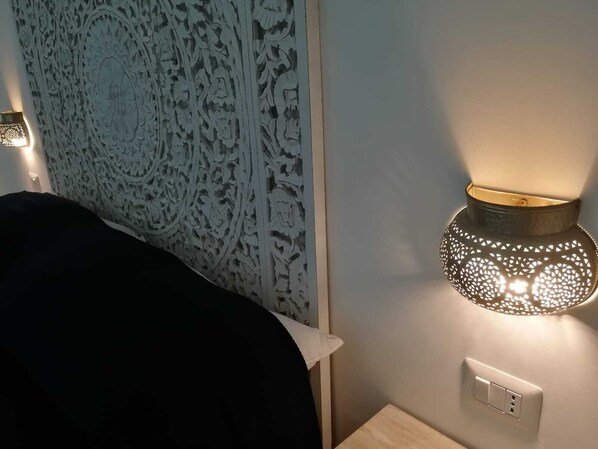 Una habitación con un panel decorativo en la pared y una lámpara fijada a la pared.