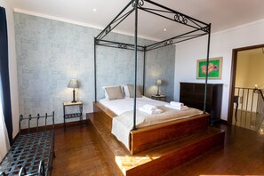 Cozy retreat with a four-poster canopy bed, fireplace, and elegant artwork.
