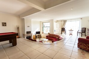 Relax in this inviting living area with a pool table, comfortable sofa, and fireplace.