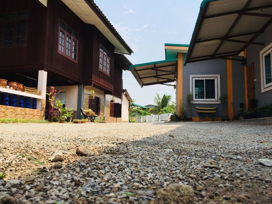 A residential area with two houses, one with a wooden facade and the other with a grey exterior.