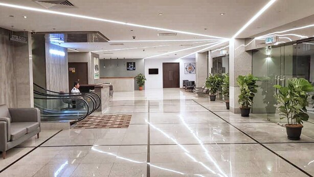 A modern hotel lobby with a reception desk, seating area, and a staircase. - Urban H Hotel (George Town)
