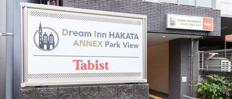 A sign for Dream Inn Hakata Annex Park View with a view of the building's exterior.