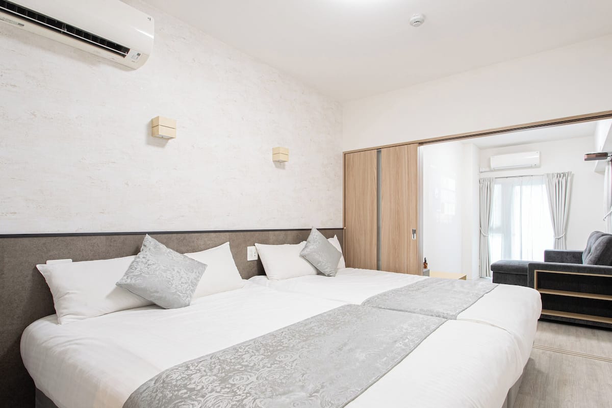 Een moderne hotelkamer met een groot bed, een kledingkast en een zithoek.