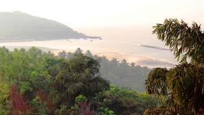 A coastal landscape with dense vegetation and a calm sea. - Raposo Holiday Resort (Vagator)