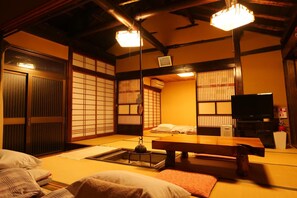 A traditional Japanese room with tatami flooring, a low wooden table, and sliding doors. - Takita kan (Iwaki)