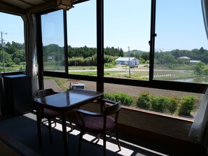 A room with a large window, a table, and two chairs. - Takita kan (Iwaki)