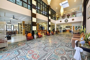 A spacious lobby with a patterned carpet, multiple seating areas, and a high ceiling with natural light. - Coco Retreat Phuket Resort and Spa Sha+ (Chalong)