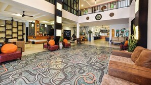A spacious lobby with a high ceiling, a reception desk, seating areas, and a patterned carpet. - Coco Retreat Phuket Resort and Spa Sha+ (Chalong)