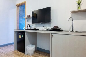 A compact kitchenette with a built-in refrigerator, a microwave, a coffee maker, a sink, and a television mounted above the counter. - Coco Retreat Phuket Resort and Spa Sha+ (Chalong)