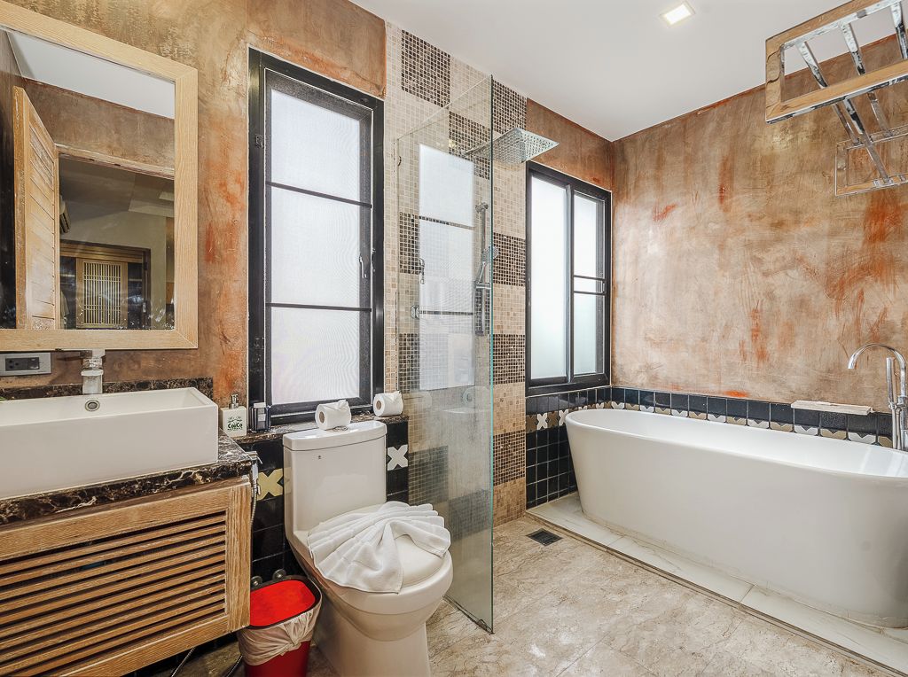 A modern bathroom with a bathtub, toilet, and shower area.