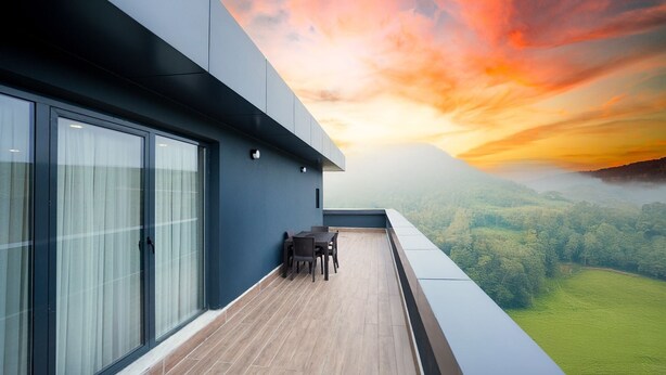 A modern balcony with a view of a forested landscape during sunset. - Hilas Thermal Resort & Spa (Samsun)