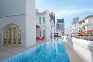 Una piscina al aire libre, sillones reclinables de piscina