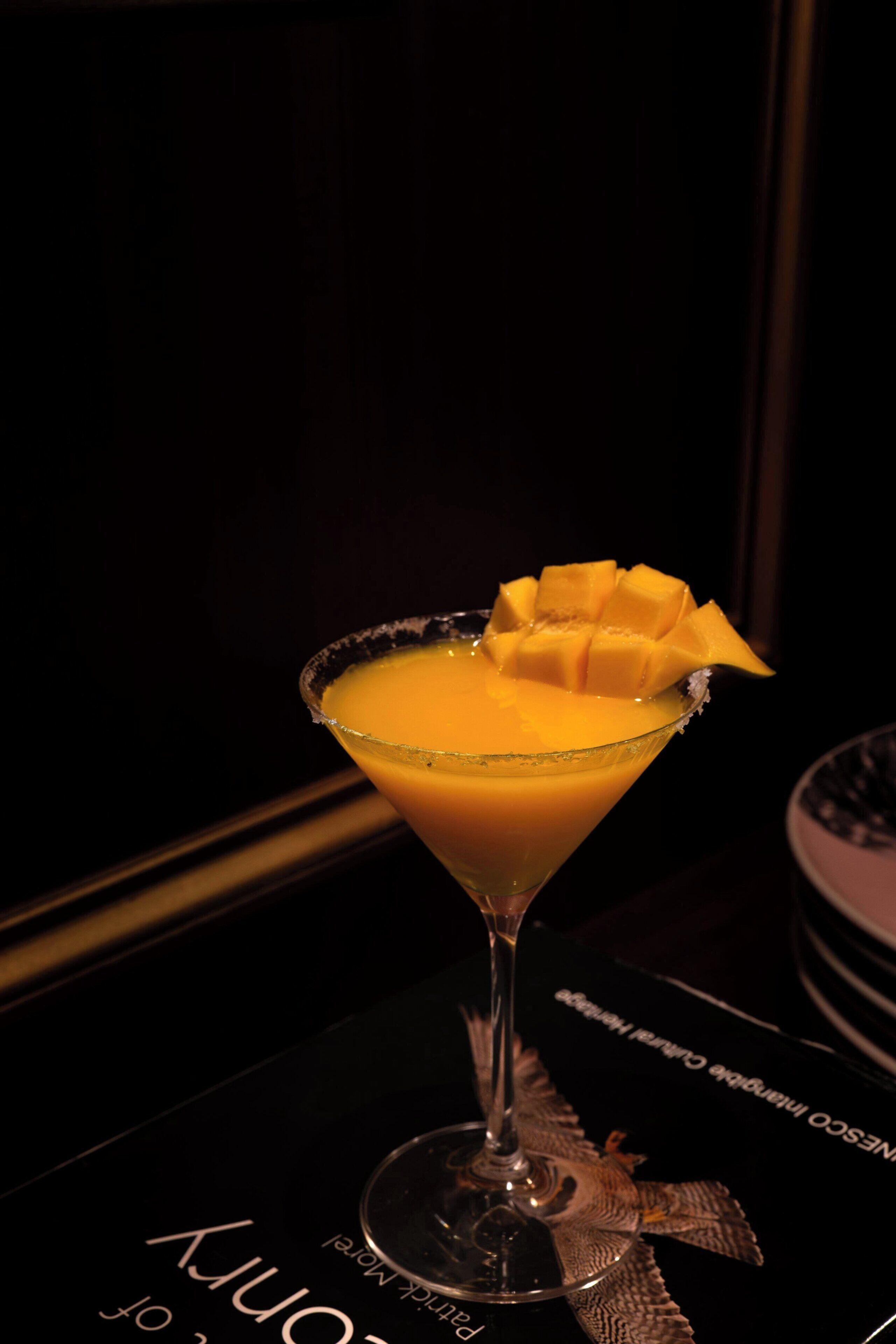 Um cocktail num copo de martini, com um guarnição na borda.
