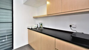 Eine moderne Küche mit Holzschränken, einer schwarzen Arbeitsplatte und einer eingebauten Spüle.