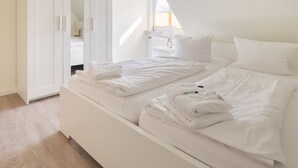 A modern bedroom with a large bed, a wardrobe, and a skylight. - FEWO auf dem Lande (Tumlauer Koog)