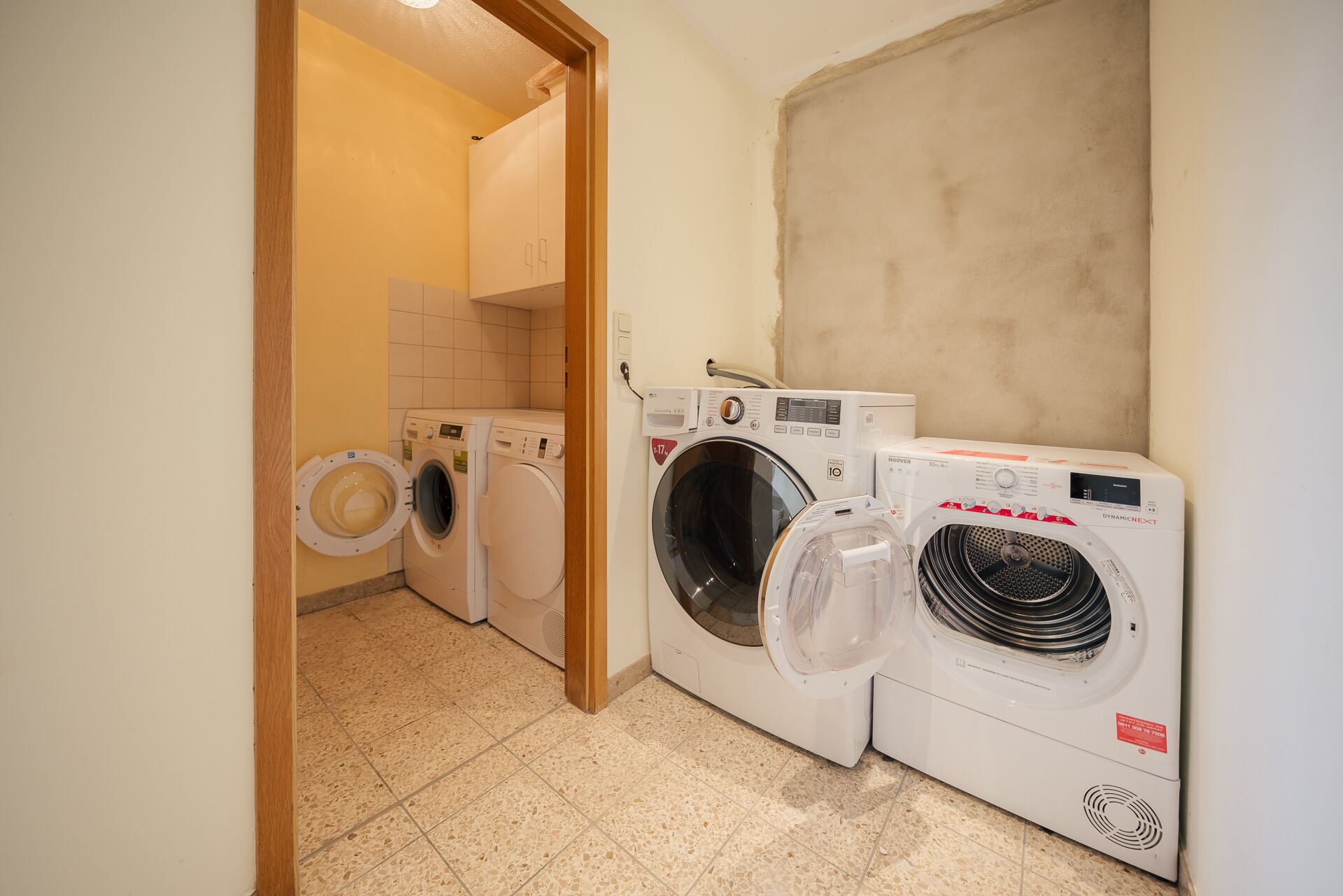 Un cuarto de lavado con dos lavadoras y una secadora.