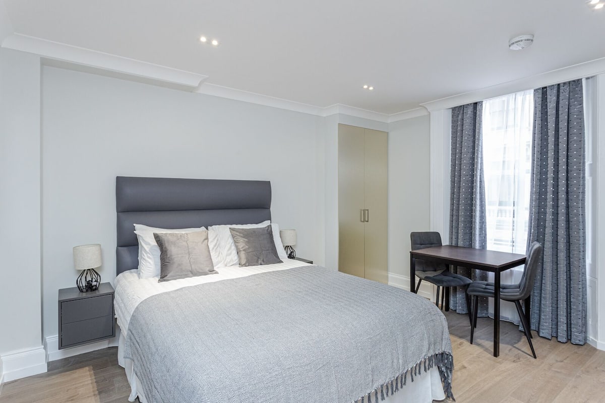 Une chambre moderne avec un grand lit, des tables de chevet, un bureau et une chaise.
