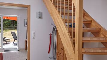 A wooden staircase leading to an upper floor, a sliding glass door to an outdoor area, and a red towel on a rack.