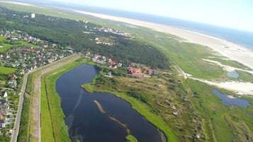 Vista aérea de un pueblo costero con un río, playa y zonas residenciales.