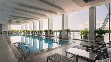 Una piscina cubierta, tumbonas