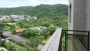 A residential area with a view of a hillside and a building with a brick facade. - Ruo Shui Hotspring Hotel (Jiaoxi)