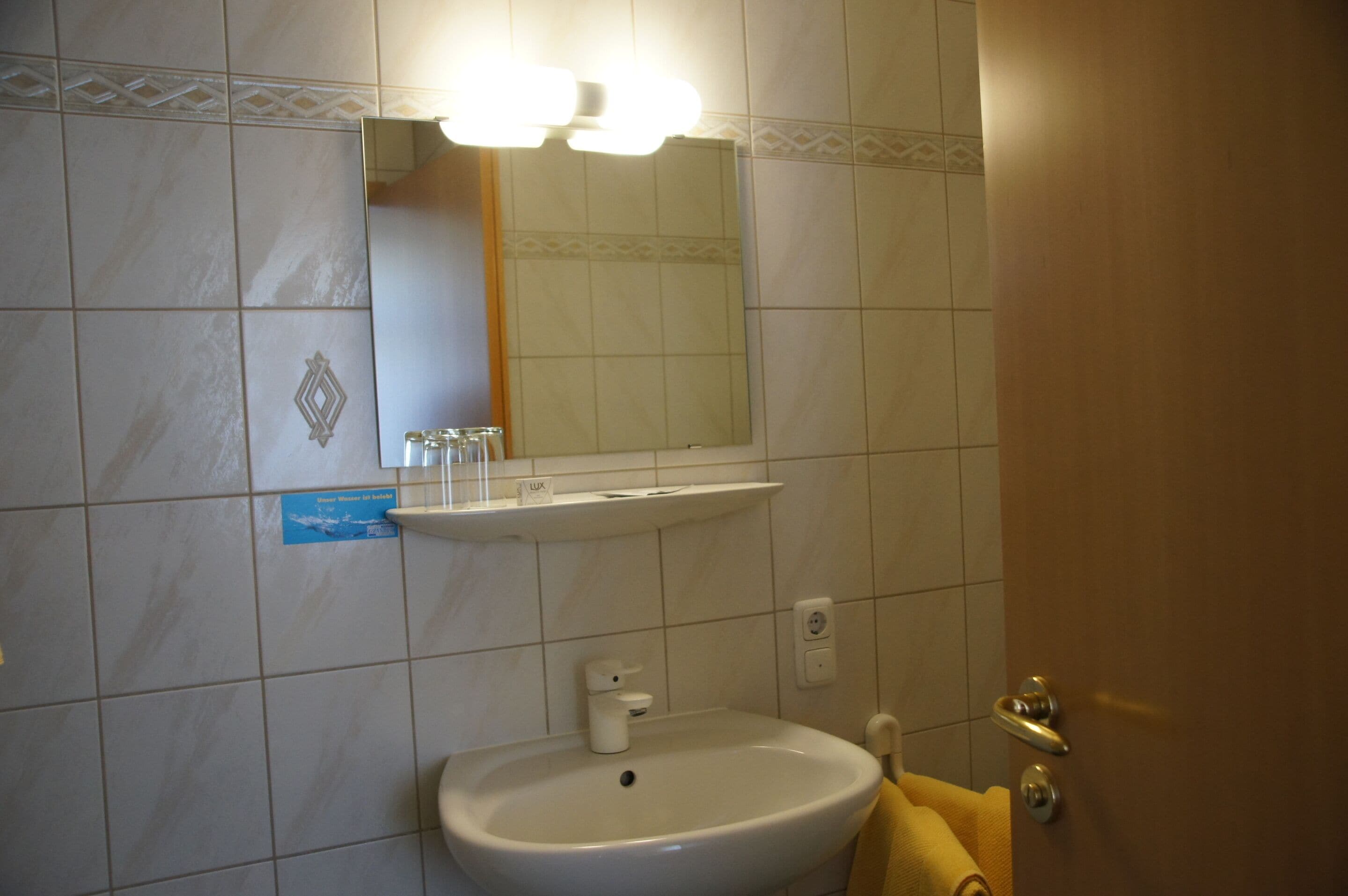 A bathroom with a sink, mirror, and towel rack.