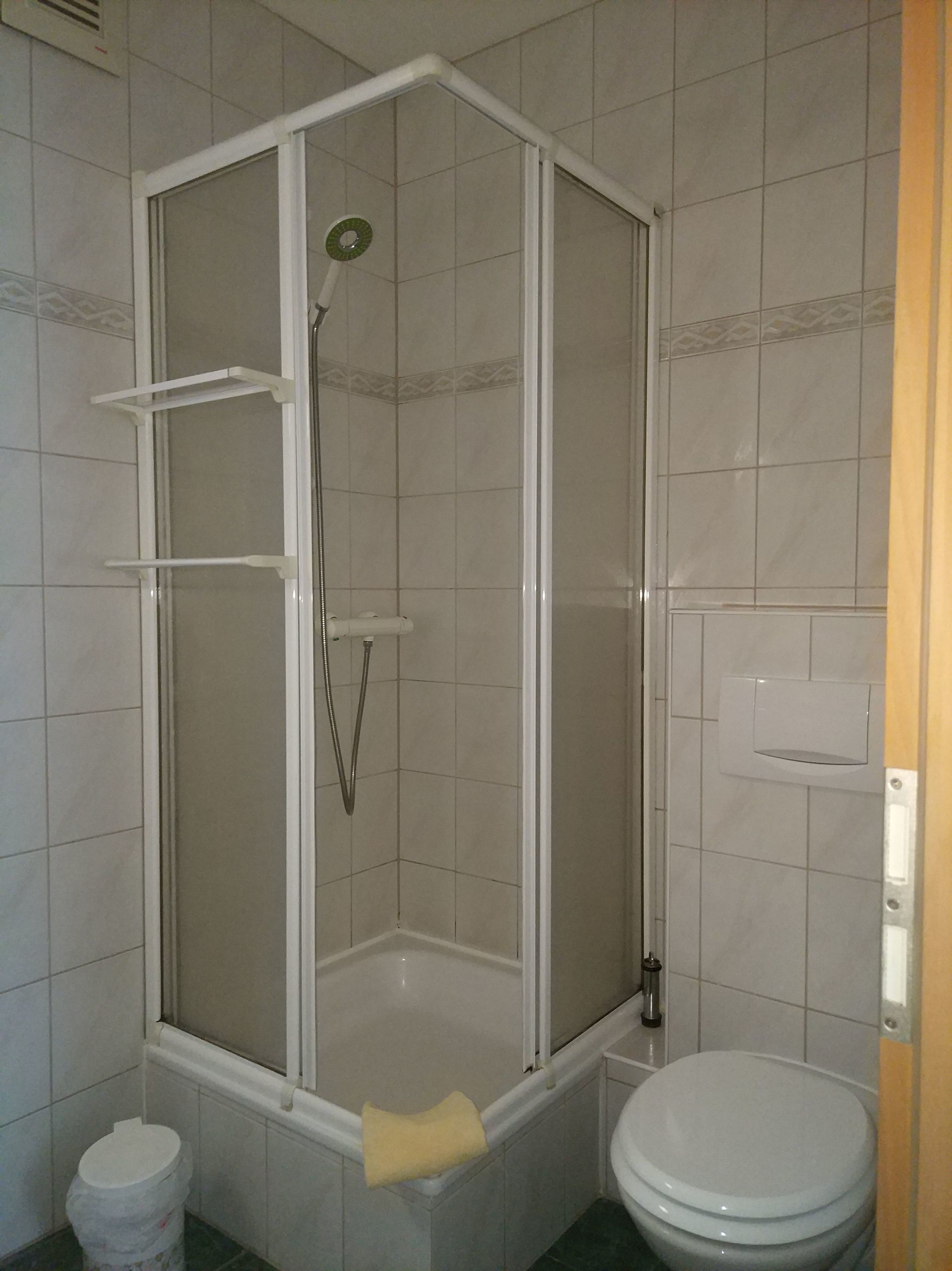 A bathroom with a shower enclosure, a bathtub, and a toilet.