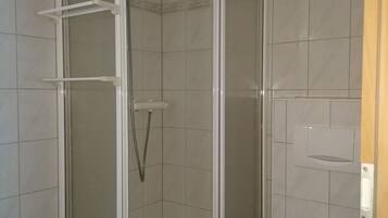 A bathroom with a shower enclosure, a bathtub, and a toilet.
