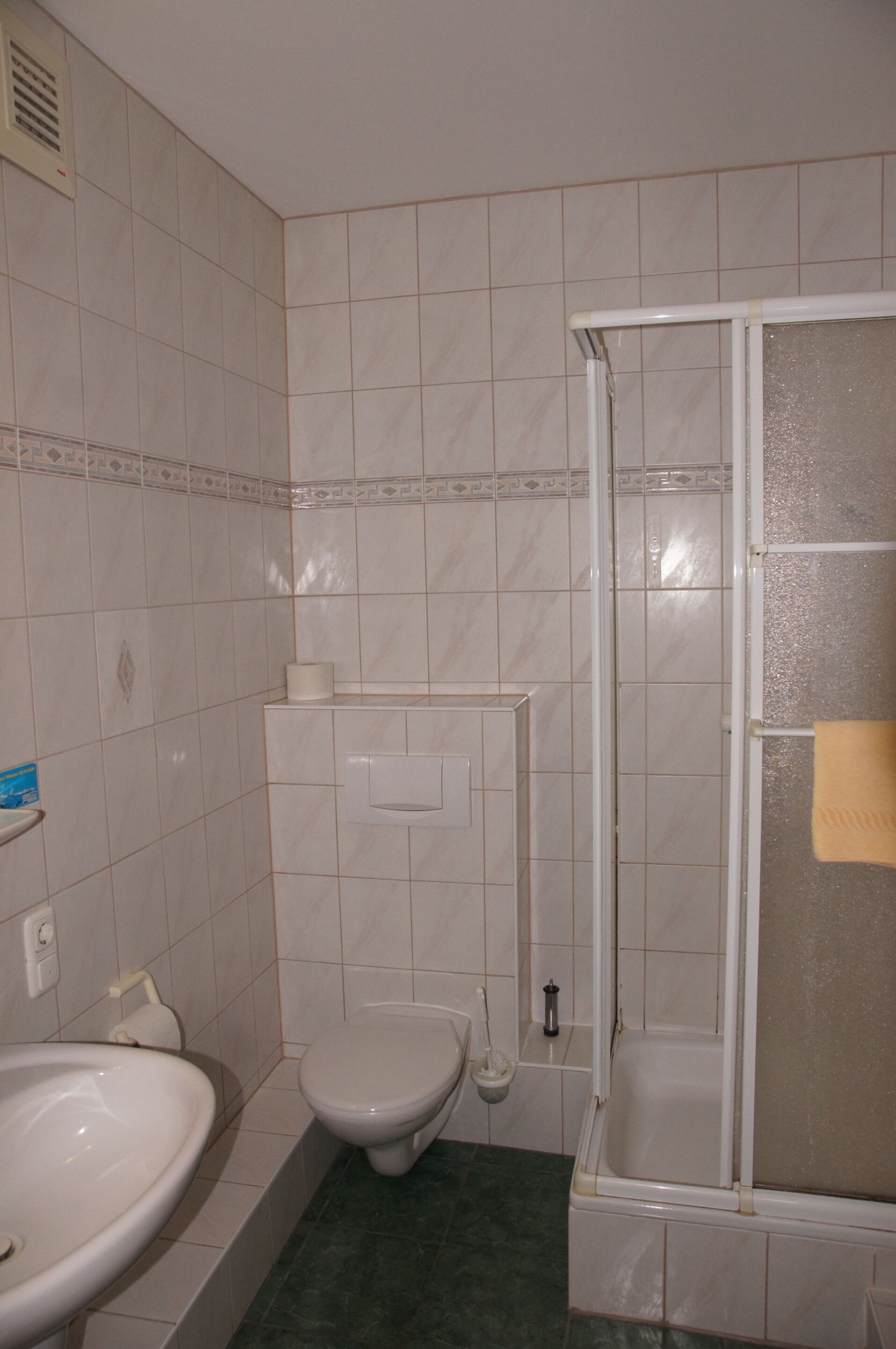 A bathroom with a toilet, sink, and shower.
