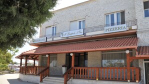 A building with a sign reading "PIZZERIA" and "RISTORANTE" indicating a restaurant and pizzeria. - Genius Hotel (Corato)