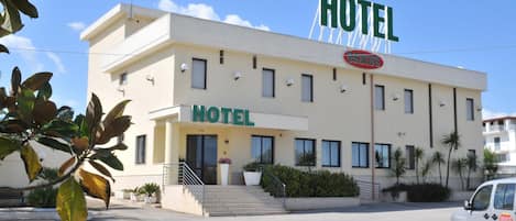 A two-story hotel with a prominent 'HOTEL' sign above the entrance.