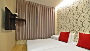 A hotel room with a bed, curtains, a wall-mounted TV, and a patterned wall. - HUA CHUN LIN Hotel (New Taipei City)
